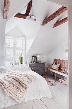 an instagram photo of a bedroom with white walls and wood beams on the ceiling