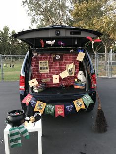 the back end of a van is decorated with cards and brooms for halloween decorations