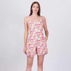 Vintage 90s grunge romper in white with a pink floral print, buttons down the front, and pockets. Measurements and Condition:  Fits like: Labeled small, but best fits petite medium (was loose on the model, who usually wears size small - see measurements below) Fabric: Rayon Brand: Lauren Brooke Condition: Excellent Length: 31.5" Chest: 36" Waist: 31" Hips: 42" Rise to shoulder: 30" Inseam: 40" Shown on a 5'9" model with measurements of 33"-24"-39", usually wears size small. See our FAQ for more Pink Vacation Jumpsuit With Pockets, Sleeveless Cotton Floral Print Jumpsuits And Rompers, Floral Print Cotton Jumpsuits And Rompers For Summer, Cotton Floral Print Jumpsuits And Rompers For Summer, Spring Jumpsuits And Rompers With Pockets And Short Length, Spring Jumpsuits And Rompers With Pockets, Spring Short-length Jumpsuits And Rompers With Pockets, Spring Short Length Jumpsuits And Rompers With Pockets, Cotton Short Length Jumpsuits And Rompers For Spring