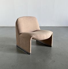 a beige chair sitting on top of a cement floor