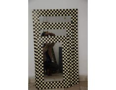 a black and white checkered frame with a person taking a photo in the mirror