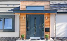 the front door of a house with two potted plants