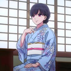 a woman in a blue kimono sitting on a chair with her hand under her chin