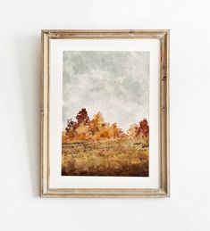 a painting hanging on the wall next to a white wall with a wooden framed frame