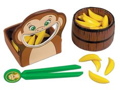 a wooden toy set with bananas and a monkey in a box next to it's contents