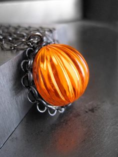 "Retro and fun--brilliant, brilliant orange pumpkin pendant necklace for Halloween! This fluorescent orange ribbed acrylic cabochon has incredible visual depth -- it reflects light almost as if if were glowing! The vintage cabochon is set in a black gunmetal bezel and suspended from a long, black gunmetal chain. -Orange Cabochon: 3/4\" (18mm) dia, 1/2\" (12mm) tall -Bezel setting: 7/8\" (22mm) dia -Length: Select from 17\" or 26\" Contact me for custom lengths! Shy Siren jewelry box is included Retro Orange Necklace Gift, Orange Necklace For Halloween Gift, Siren Jewelry, Pumpkin Ring, Pumpkin Necklace, Fluorescent Orange, Halloween Necklace, Day Glow, Goth Jewelry