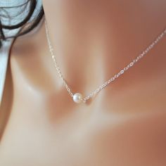 "This freshwater pearl choker is so delicate and pretty. A creamy white, genuine pearl is centered on fine, sterling silver chain. This lovely pearl is almost perfectly round and measures about 6-7mm in diameter. The pearl sits right at the hollow of your throat, making this a great layering piece. Little pearls connect the sterling lobster clasp. Prefer gold? Click below for the gold-filled version of this necklace: http://www.etsy.com/listing/155980428/new-white-pearl-choker-freshwater-pearl?r Single Pearl Necklace, Simple Silver Jewelry, Diamond Bar Necklace, Floating Necklace, Single Pearl, Fine Silver Jewelry, Pearl Choker Necklace, Silver Jewelry Fashion, White Freshwater Pearl