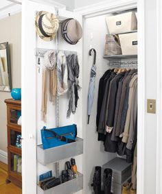 an open closet with clothes and hats hanging on the wall next to a blue purse