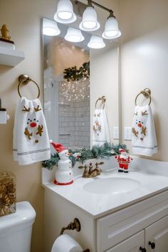 a bathroom decorated for christmas with white towels