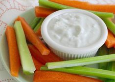 carrots, celery and celery sticks on a plate with dip