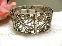 Antique filigree floral link bracelet made of silver wire with oriental-looking Flower ornaments from the Art Nouveau period. Transition Art Deco 20s/30s. Today, priceless handwork, elaborately designed. The material is silver, hallmarked 835. Very good condition with light patina a unique, old, antique piece of jewelry Please note that it only fits very narrow wrists! Maybe you could add more silver rings at the end, to extend it and then close it with a spring washer. Please note that this is Silver Filigree Bracelets For Wedding, Sterling Silver Filigree Bracelet For Wedding, Wedding Metal Bracelets With Filigree, Wedding Metal Bracelets With Filigree Details, Wedding Bracelets With Filigree Metal, Antique Silver Filigree Bracelets For Wedding, Ornate Sterling Silver Bracelet For Wedding With Intricate Design, Ornate Handmade Sterling Silver Wedding Bracelet, Antique Filigree