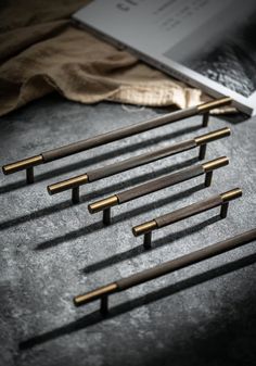 five wooden handles are lined up next to a book on a table with other items