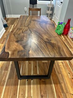 a wooden table sitting on top of a hard wood floor next to a door and window