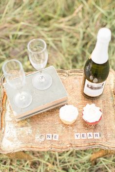 a bottle of wine and some cupcakes on a table