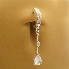 Above is a beautiful solid 925 sterling silver exclusive clear cz pave set TummyToys belly button ring. Fixed to the bottom is a sterling silver and clear pear and round cz drop charm. No other body jewelry offers the convenience, security and beauty of real jewelry like TummyToys. All TummyToys belly button rings are created with you in mind they are comfort fit and will not snag on clothing. Our easy to use patented snap-in design makes it the world's best navel ring. No more struggling with a Elegant Cubic Zirconia Belly Rings, Elegant Round Cubic Zirconia Belly Rings, Silver Cubic Zirconia Piercings With Sparkling Stones, Elegant Silver Piercings With Sparkling Stones, Elegant Cubic Zirconia Belly Rings As Gift, Wedding Piercings In White Gold With Cubic Zirconia, White Gold Cubic Zirconia Piercings For Wedding, Wedding White Gold Piercings With Cubic Zirconia, Cubic Zirconia Belly Rings For Gift