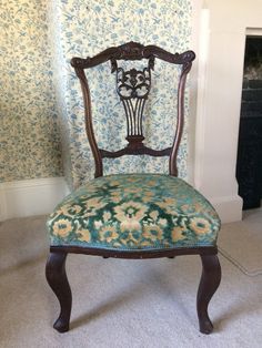 an antique chair with floral upholstered fabric