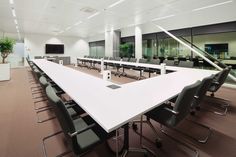 an empty conference room with long tables and chairs