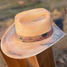 Take on the wild west in style with our Blessed Hand Painted Hat. Made from premium straw, this small-sized cowboy hat is a statement piece. Hand painted flowers and vintage details, accented with metal feathers, add a unique touch. Kentucky Derby Straw Hat With Curved Brim For Rodeo, Rustic Curved Brim Straw Hat For Kentucky Derby, Kentucky Derby Country Straw Hat With Curved Brim, Bohemian Toquilla Straw Fedora For Kentucky Derby, Country Style Curved Brim Straw Hat For Kentucky Derby, Rustic Flat Brim Straw Hat, Artisan Straw Hat For Rodeo, Southwestern Wide Brim Fedora For Kentucky Derby, Rustic Wide Brim Straw Hat For Kentucky Derby