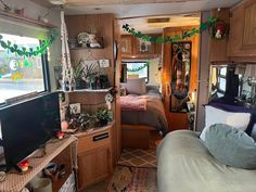 the inside of a camper with lots of plants and decorations on the windowsill