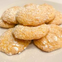 some sugar cookies on a white plate with powdered sugar sprinkled on top