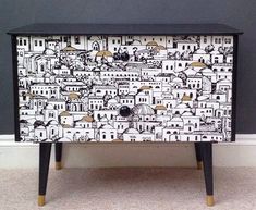 a black and white dresser with an artistic design on the front, side or drawer