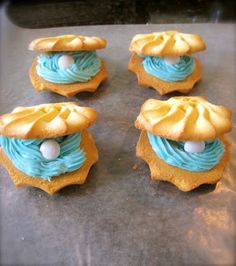 some cupcakes with blue frosting and yellow icing on top are sitting on a baking sheet