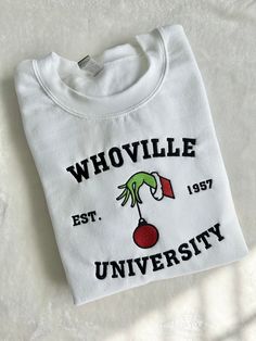 "Whoville Christmas Holiday Embroidered Sweatshirt. If you want a different thread color please message us first and put your color change request in the \"Buyers Notes\" during checkout. Material: 100% Cotton Ribbed Neckline, hem and cuffs Fit: Shirts are UNISEX MEN: Order Regular Size WOMAN: Order 1 Size down for tighter fit Care: Wash with like colors using warm water. Tumble dry medium or low." Whoville University Sweatshirt, Whoville Sweatshirt, Grinch Sayings, Christmas Sweatshirt Ideas, Whoville University, Grinch Stuff, Christmas Checklist, Sweatshirt Ideas, Whoville Christmas