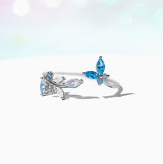 This ring is oh, so perfect. From the radiant array of blue crystals to the adjustable nature of the band, this ring has so many elements that only adds to it's elegance. Featuring a string of leaves on one end and a cute little butterfly on the other, our Perfect Petal Ring is just the piece to add to your garden of jewels. Adjustable Blue Crystal Wedding Ring, Blue Adjustable Crystal Wedding Ring, Adjustable Crystal Ring For Gift, Elegant Adjustable Blue Flower Ring, Elegant Blue Adjustable Flower Ring, Adjustable Blue Crystal Promise Ring, Blue Adjustable Crystal Promise Ring, Blue Crystal Wedding Ring, Blue Butterfly Ring