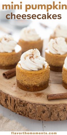 mini pumpkin cheesecakes on a wooden board with cinnamon sticks and whipped cream in the middle