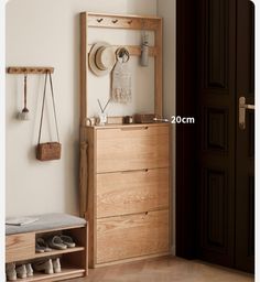 a wooden dresser sitting next to a wall with shoes hanging on the door and a hat rack above it