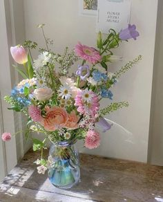 a vase filled with lots of different colored flowers