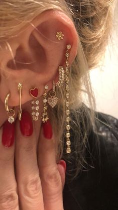 a close up of a person's ear with three different types of earrings on it