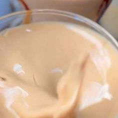 a glass filled with cream sitting on top of a table