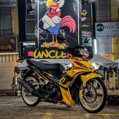 a yellow and black motorcycle parked in front of a sign with an eagle on it