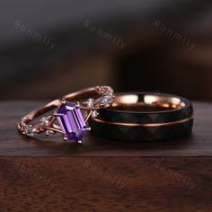 two wedding rings sitting on top of a wooden table next to another ring with an ameth