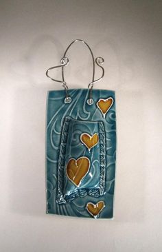 a ceramic wall hanging with hearts on it