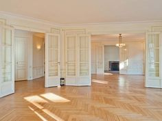 an empty room with wooden floors and white walls