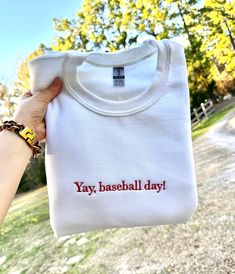 someone holding up a t - shirt that says yay, baseball day