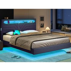 a bed that has some lights on the headboard and night stands in front of it