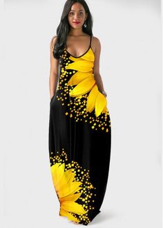 a woman wearing a black and yellow dress with sunflowers on the side, standing in front of a white background