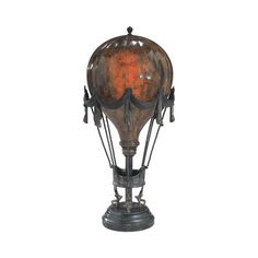 an old fashioned air balloon on a stand with rusted paint and metal accents, isolated against a white background