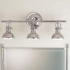 three light bathroom fixture with chrome finish and white walls in the background, along with a mirror