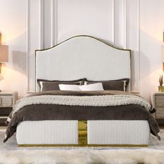 a large bed sitting in the middle of a bedroom next to two nightstands and lamps