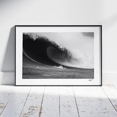 a black and white photo of a person surfing on a large wave in the ocean