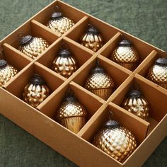 an open box filled with gold christmas ornaments