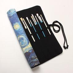 the case is made out of fabric and has six brushes in it, including one with a starry night painting on it