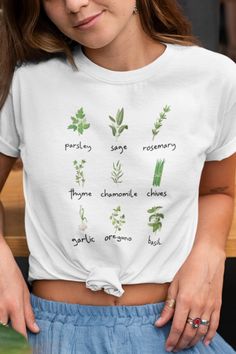 FREE SHIPPING ON ORDERS OF $35 OR MORE!! Wear this cute herb shirt when you are in the garden or hanging out! Shows parsley, sage, rosemary, thyme, chamomile, chives, garlic, oregano, and basil. Design is printed direct-to-garment on Bella Canvas shirt - so it is super soft, fits well, and the 100% cotton fabric breathes incredibly. Makes the perfect plant lover gift. This classic unisex jersey short sleeve tee fits like a well-loved favorite. Soft cotton and quality print make users fall in lov Organic Crew Neck Tops For Spring, Organic Green Short Sleeve Top, Spring Green Tops With Plant Details, Green Plant Print Tops For Gardening, Green Tops With Plant Print For Gardening, Green T-shirt With Plant Print For Gardening, Green Plants Print T-shirt For Gardening, Green Tops With Letter Print For Gardening, Soft Fits