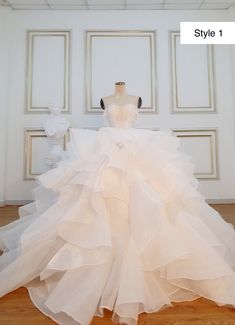 a white wedding dress is on display in a room