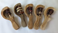 four wooden toothbrushes lined up in a row on a white surface, one is made out of wood