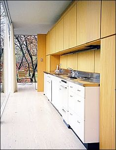 an empty kitchen with wooden cabinets and white counter tops is seen in this image from the outside